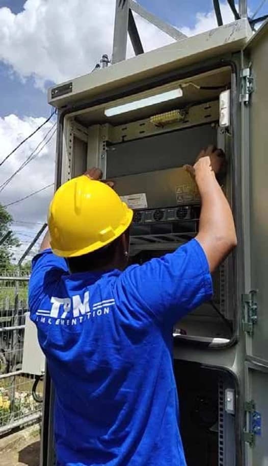 Technician replacing industrial backup batteries